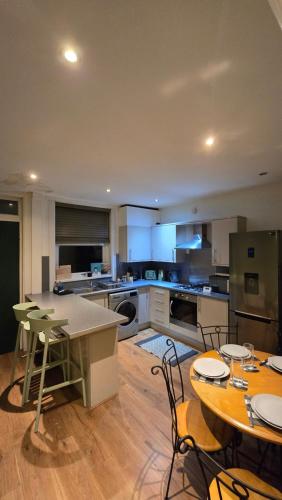 a large kitchen with tables and chairs in it at Cosy 3 Bedroom, 5 Bed House! in Headingley