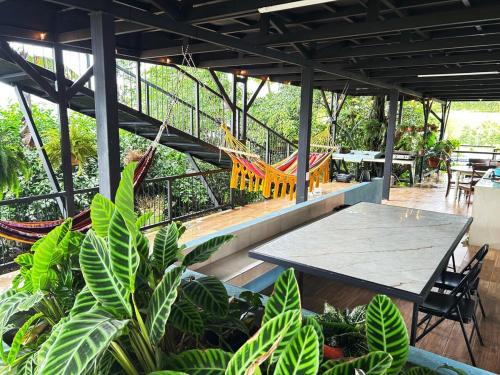 a patio with a hammock and a table and chairs at Azulita Oasis, Family-Sized Loft With Pool & Large Outdoor Areas in Aguas Zarcas