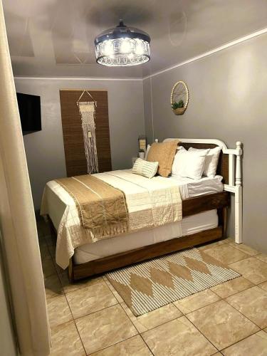 a bedroom with a bed and a chandelier at Azulita Oasis, Family-Sized Loft With Pool & Large Outdoor Areas in Aguas Zarcas