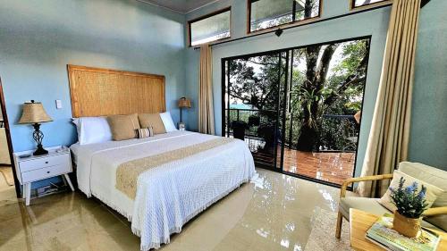 a bedroom with a bed and a large window at Azulita Oasis, Family-Sized Loft With Pool & Large Outdoor Areas in Aguas Zarcas