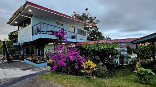 a house with purple flowers in front of it at Azulita Oasis, Family-Sized Loft With Pool & Large Outdoor Areas in Aguas Zarcas