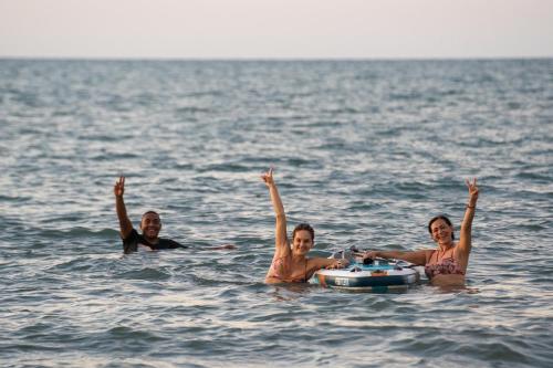 a group of three people in the water at Casa del Mar by Al Alma in San Onofre