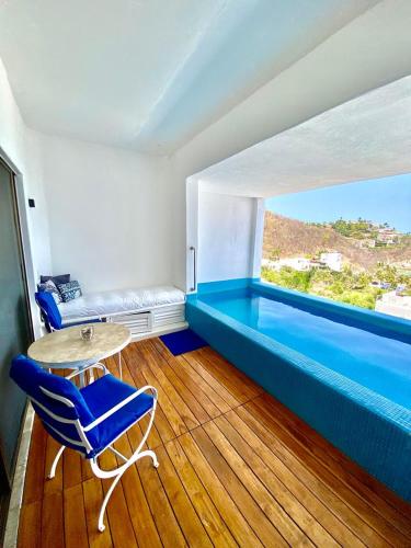 a room with a blue couch and a table and chairs at Condos Privados en Huatulco in Tangolunda