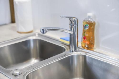 - un évier de cuisine avec une bouteille de savon à côté dans l'établissement APPARTEMENT "Ti CABANE" villa Bel Kay Nou, à Sainte-Luce