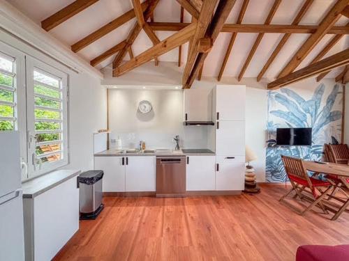 une cuisine avec des armoires blanches et un plancher en bois dans l'établissement APPARTEMENT "Ti CABANE" villa Bel Kay Nou, à Sainte-Luce