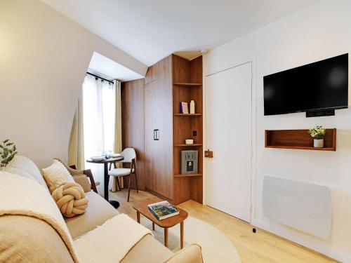 un salon avec un canapé et une télévision dans l'établissement Modern studio - 2P - AC - Madeleine Saint-Lazare, à Paris