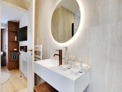 une salle de bain avec un lavabo et un miroir au mur dans l'établissement Modern studio - 2P - AC - Madeleine Saint-Lazare, à Paris