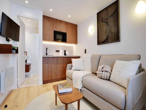 un salon avec un canapé et une table dans l'établissement Modern studio - 2P - AC - Madeleine Saint-Lazare, à Paris