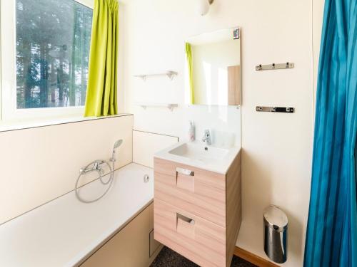 a bathroom with a sink and a mirror at Stylish Retreat with Sauna in Awenne