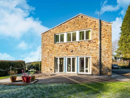 a brick house with large sliding glass doors at Stylish Retreat with Sauna in Awenne