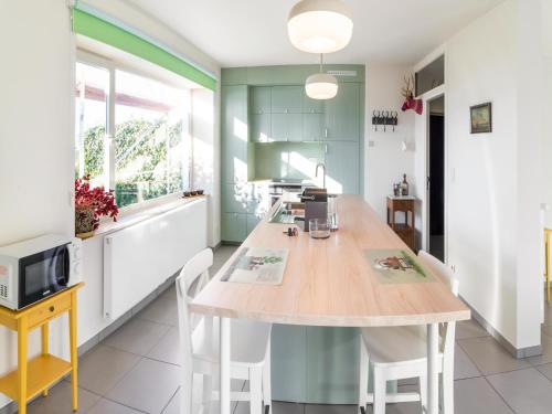 a kitchen with a wooden table and chairs at Stylish Retreat with Sauna in Awenne