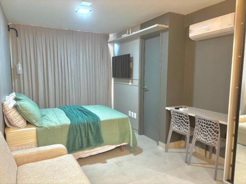 a bedroom with a bed and a desk in a room at UMI Flats - Intermares in Cabedelo