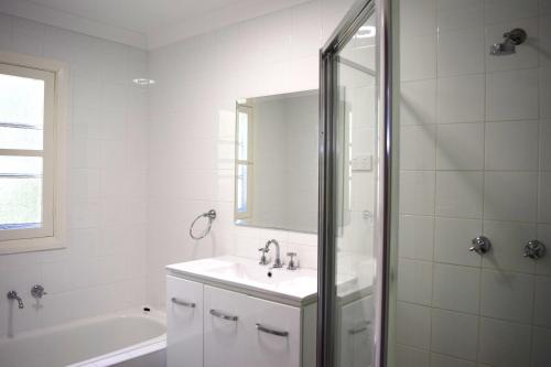 a white bathroom with a sink and a shower at Clanwilliam in Blackheath