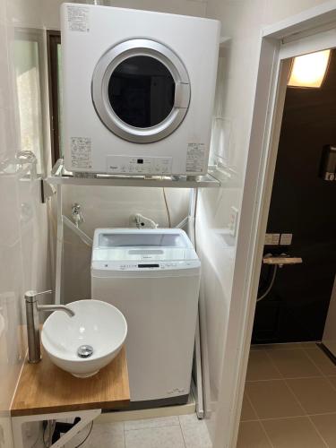 a small bathroom with a sink and a washing machine at BANKSHI-SA in Motobu