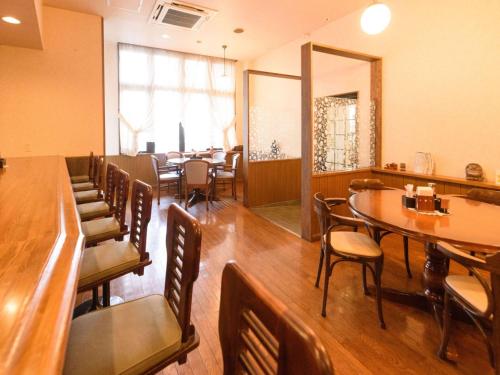 a dining room with tables and chairs and a mirror at Business Hotel Kawakami in Kumano