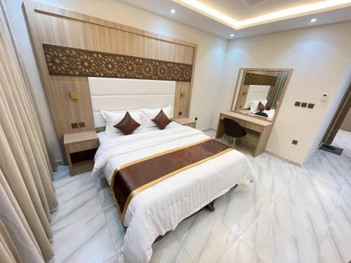 a bedroom with a large bed and a mirror at كويت سفن للشقق المخدومة in Jeddah