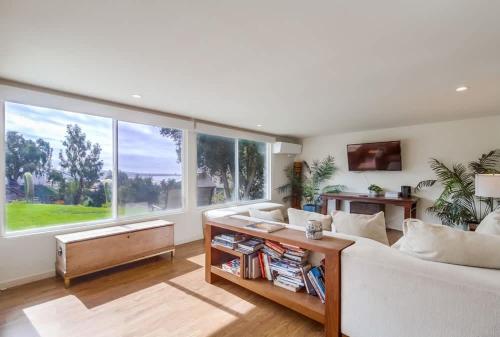 a living room with a white couch and a large window at Best Ocean & Bay Views in SD Large Backyard Air Conditioning in San Diego