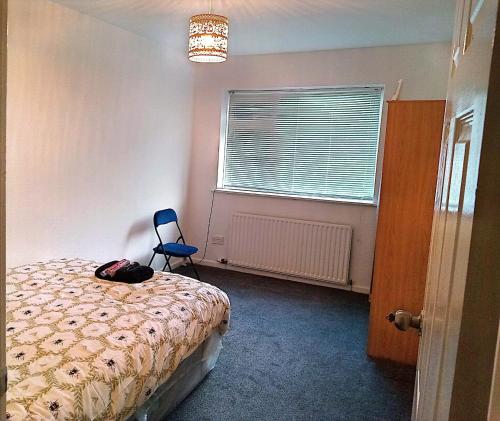 a bedroom with a bed and a chair and a window at YPCC Rhodesway in Bradford