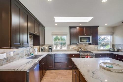a large kitchen with wooden cabinets and a counter top at Best Ocean & Bay Views in SD Large Backyard Air Conditioning in San Diego
