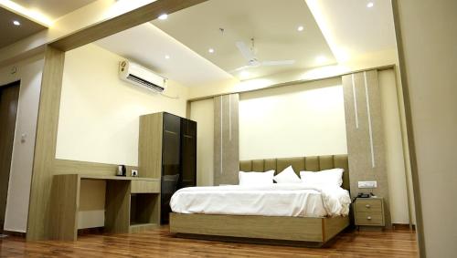 a bedroom with a bed and a large window at Hotel Royal Bistro in Mehsāna