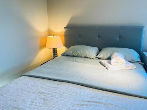 a bed with two towels on top of it at Bedrooms in Kenaston, Close to Walmart, Costco, IKEA, Outlet, Unversity of Manitoba in Winnipeg