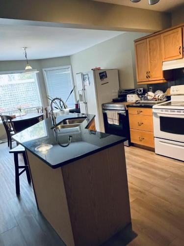 a kitchen with a large island in the middle at Bedrooms in Kenaston, Close to Walmart, Costco, IKEA, Outlet, Unversity of Manitoba in Winnipeg