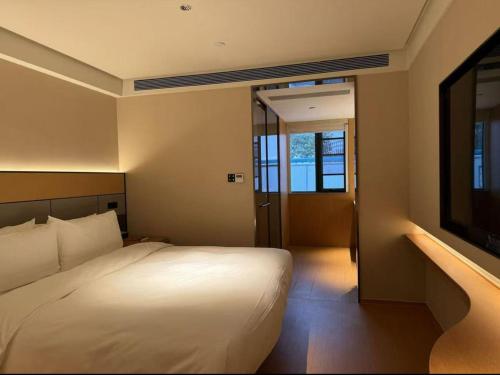 上海Ji Hotel Shanghai Pudong Airport的一间带床和平板电视的卧室