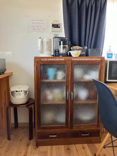 a cabinet with glass doors in a room at Shioya Hostel in Akune