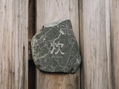 a rock on a wooden fence with writing on it at RITA Izumifumoto in Izumi