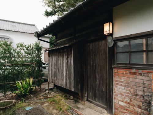 a wooden house with a door and a window at RITA Izumifumoto in Izumi