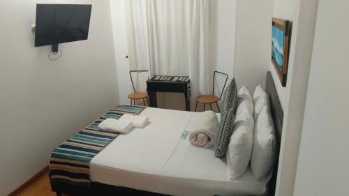 a bedroom with a bed with towels on it at Hotel Guatatur in Guatapé