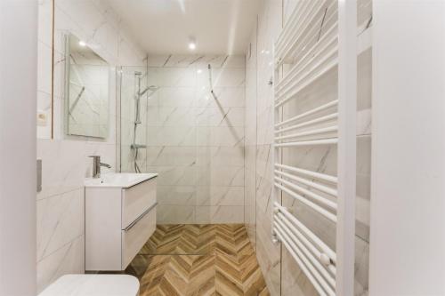 a white bathroom with a toilet and a sink at Apartament pod Gubają in Zakopane