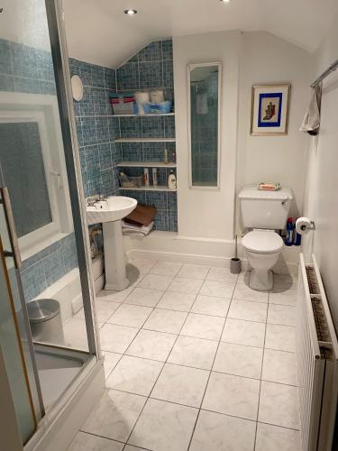 a bathroom with a toilet and a sink at Bickley London Holiday Home in Bromley