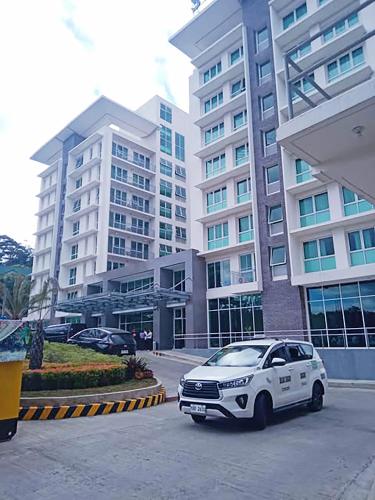 a white car parked in front of a building at New and cozy Baguio condo near SM in Baguio
