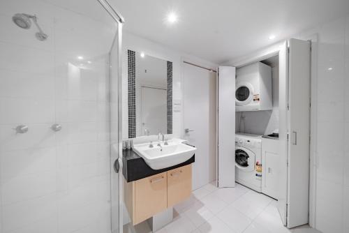 キャンベラにあるStylish 1-Bed Flat with Pool BBQ & Sauna Accessの洗面台と洗濯機を備えたバスルーム
