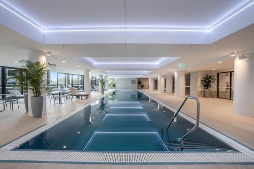 an indoor pool in a building with tables and chairs at Modern 2-Bed Apartment with Premium Amenities in Phillip