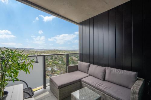 a living room with a couch and a large window at Modern 2-Bed Apartment with Premium Amenities in Phillip