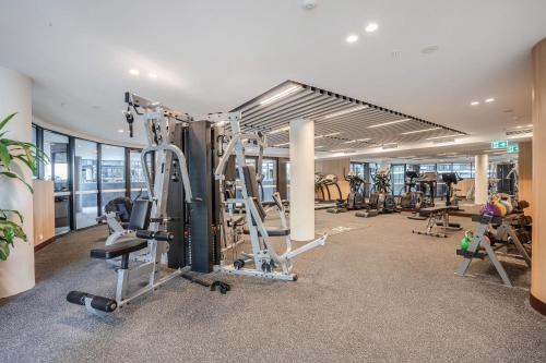 a gym with a lot of treadmills and machines at Modern 2-Bed Apartment with Premium Amenities in Phillip