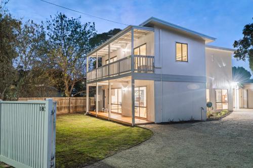 a large white house with a fence at The Big Isle Retreat in Cowes
