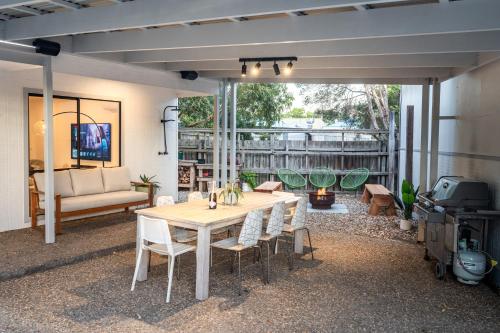 a patio with a table and chairs and a grill at The Big Isle Retreat in Cowes