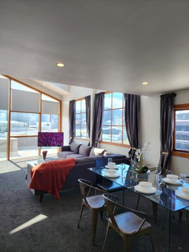 a living room with a couch and a table and chairs at U Suites on Courtenay in Wellington