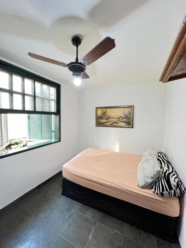 a bedroom with a bed and a ceiling fan at Village prainha in Arraial do Cabo