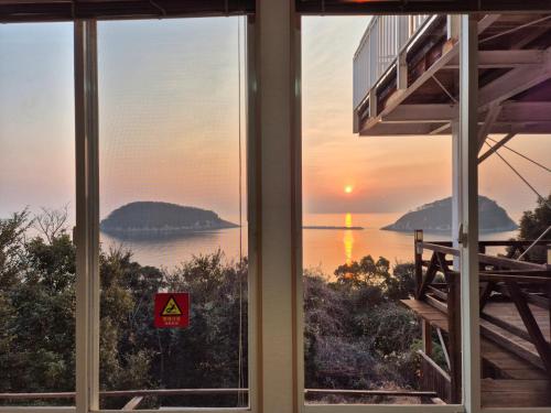 a view of the ocean from a house window at 대마도쇼핑구마에하우스 in Tsushima