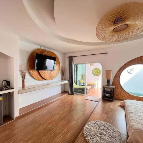 a living room with a couch and a tv on the wall at Lala Villa Koh Larn in Ko Larn