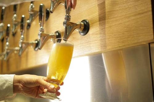 a person is holding a glass of beer at Hotel Nupka in Obihiro