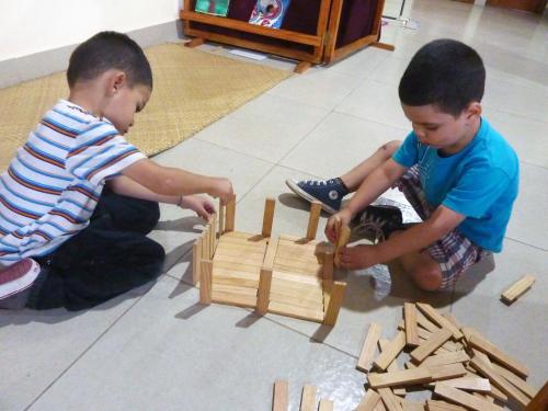 two young boys playing with a wooden toy at Hotel Casa Vínculos in Estelí