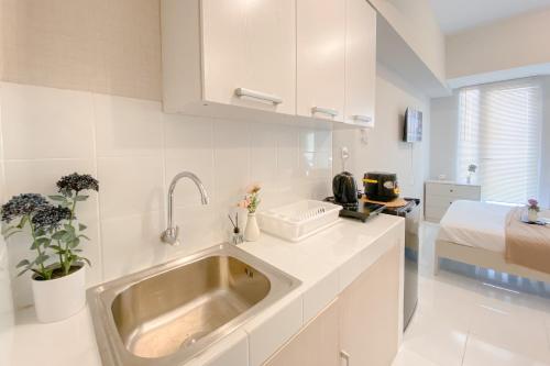 eine Küche mit Spüle und ein Bett in einem Zimmer in der Unterkunft Good Deal and Restful Studio at Apartment Tokyo Riverside PIK 2 By Travelio in Tangerang