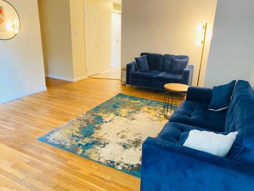 a living room with two blue couches and a rug at 1 bedroom patio view with shared bathroom #2 in Laurel