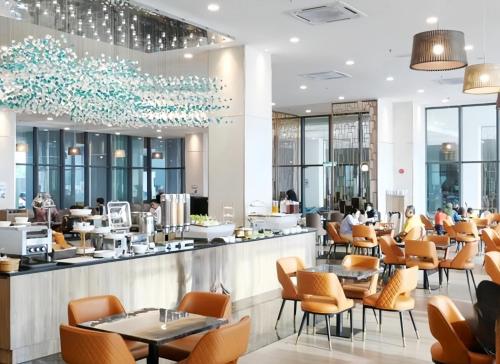 a restaurant with orange chairs and tables and a bar at Imperium Residence Kuantan in Kuantan