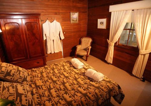 a bedroom with a bed and a dresser and a chair at Hermitage Cottage in Kurrajong